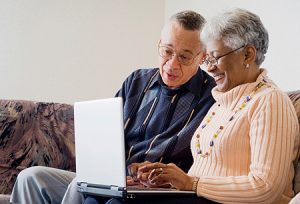 photo of an elderly couple looking at a laptop